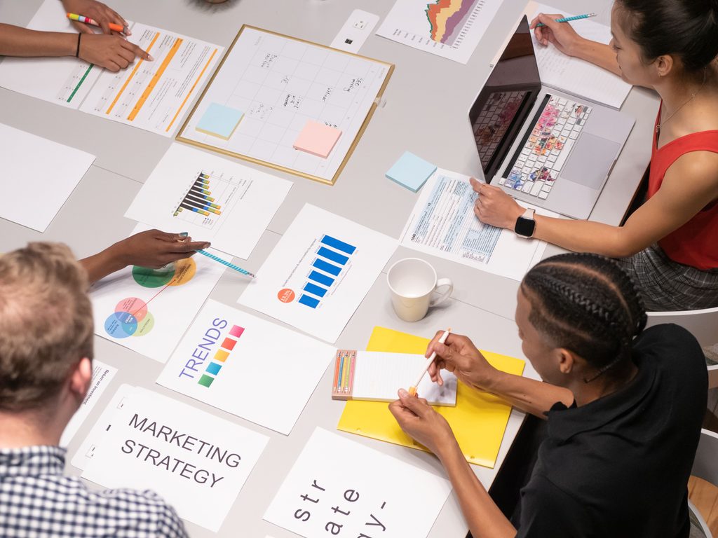 Marketing team collaborating over strategy documents and charts